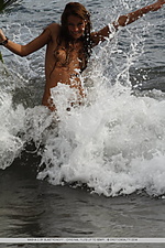 Ocean palm fun and carefree, masha frolics on beach, with sand and frothy water on her tight, untrimmed body.