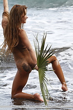 Ocean palm fun and carefree, masha frolics on beach, with sand and frothy water on her tight, untrimmed body.