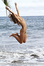 Ocean palm fun and carefree, masha frolics on beach, with sand and frothy water on her tight, untrimmed body.