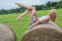 Playing in the hay bernie strips outdoors as she playfully poses on the hay.